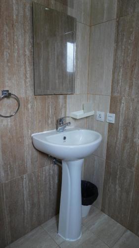 a bathroom with a white sink and a mirror at Diyar Villas Puncak K3/2A in Puncak
