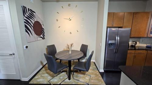 a kitchen with a table and chairs and a clock on the wall at Galleria Luxury Stay Pool Gym Stunning Views in Houston