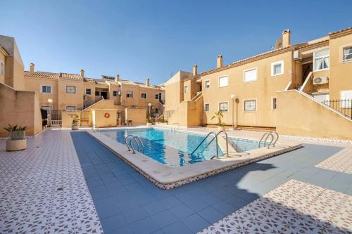 a swimming pool in a courtyard of a building at Charming Studio in Torrevieja, 75 sqm with Shared Pool in Torrevieja