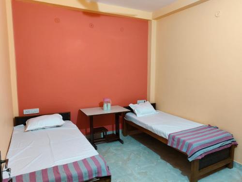 a room with two beds and a small table at MAYUR paying Guest house in Varanasi