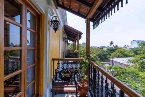 a balcony of a house with benches on it at La Moon Puducherry in Puducherry