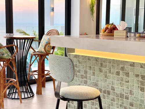 a kitchen with a counter with chairs and tables at AIR Condominium & Residence - Sihanoukville - 5mn to boat pier in Sihanoukville