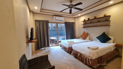a hotel room with two beds and a window at Sunrise Resort- Koh Phangan - SHA Extra Plus in Haad Rin