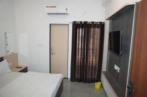 1 dormitorio con 1 cama y puerta con cortina en Shree radhe mohan hotel and resort khatushyamji, en Khātu