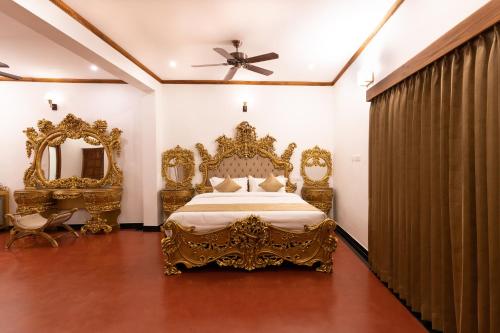 a bedroom with a gold bed and a mirror at La Moon Puducherry in Puducherry