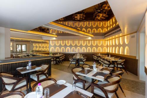 a restaurant with tables and chairs and a bar at La Moon Puducherry in Puducherry