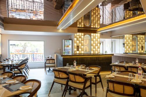 a restaurant with tables and chairs in a room at La Moon Puducherry in Puducherry