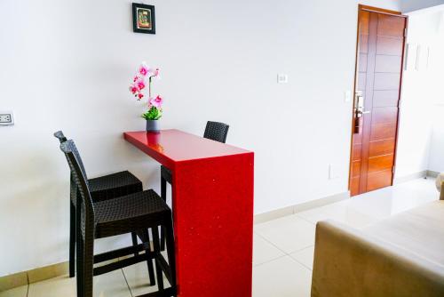a red desk in a room with two chairs at Apart Hotel Petit Palace Suites in Lima