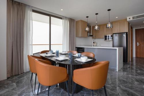 a kitchen with a black table and orange chairs at Elite Atoll Serviced Apartments Phuket in Rawai Beach