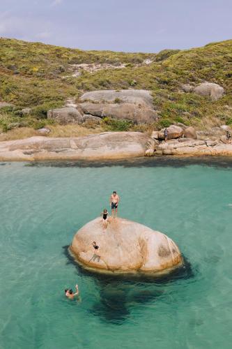 two people standing on a rock in the water at Parrys Estate at Parry Beach in Parryville