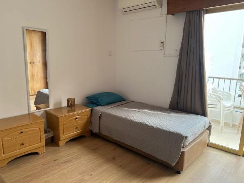 a bedroom with a bed and a dresser and a window at 2 Bedrooms larnaca Finikoudes in Larnaka