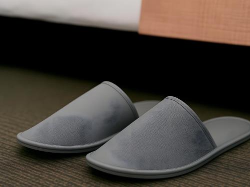 two gray slippers are sitting on a floor at Apart Hotel Petit Palace Suites in Lima