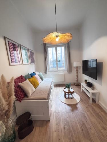a living room with a couch and a flat screen tv at SYLOU - Centre historique, 4 personnes, Climatisation, Netflix, Comédie, Tramway, Gare in Montpellier