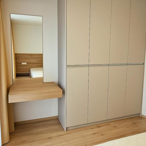 a bedroom with white cabinets and a mirror at Apartmán Madal pri Bešeňovej in Liptovská Teplá