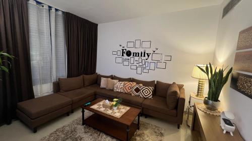 a living room with a brown couch and a table at XD Cozy Apartments in Abu Dhabi