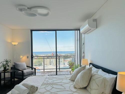 a bedroom with a large bed with a large window at CBD Penthouse Retreat - Stunning Ocean & City View in Wollongong
