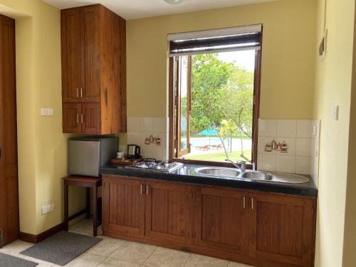 a kitchen with a sink and a window at Ensenada Bolgoda in Piliyandala