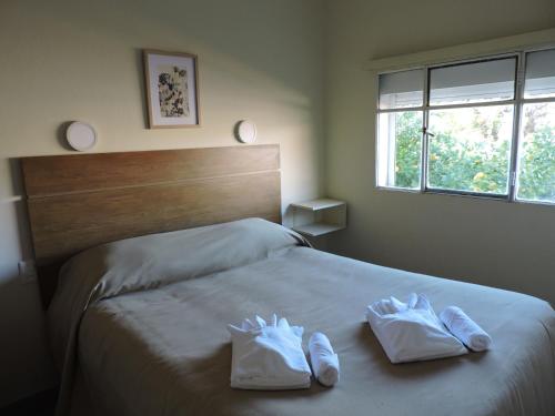 a bedroom with a bed with two white shoes on it at HOTEL CENTRAL - Estacionamiento in Treinta y Tres