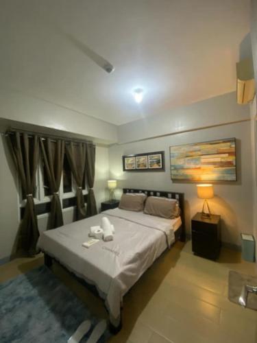 a bedroom with a bed with two towels on it at M&N Condotel in Manila