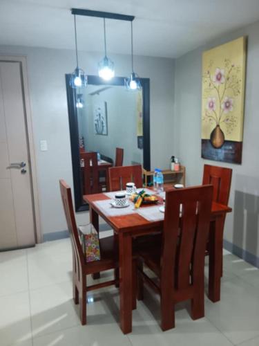 a dining room with a wooden table and chairs at M&N Condotel in Manila