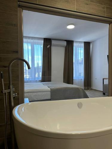 a bathroom with a bath tub and a bed at Inn West Hotel by Pysanka in Kolomyya