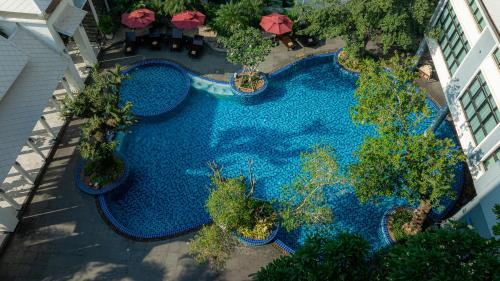 an overhead view of a swimming pool with plants and umbrellas at Bay Beach Resort Jomtien in Jomtien Beach