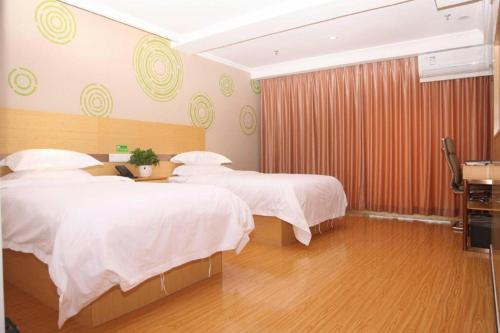 a hotel room with two beds with white sheets at GreenTree Inn Beijing Shunyi Fengbo Metro Station in Beijing