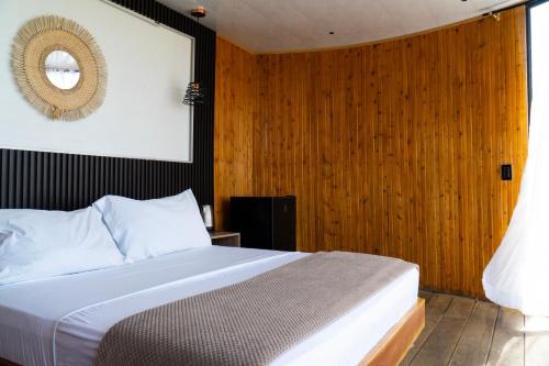 a bedroom with a bed with a wooden wall at Oasis Barichara in Barichara