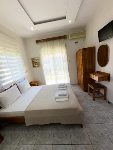 a bedroom with a large bed and a television at Studios Melida in Skala Potamias