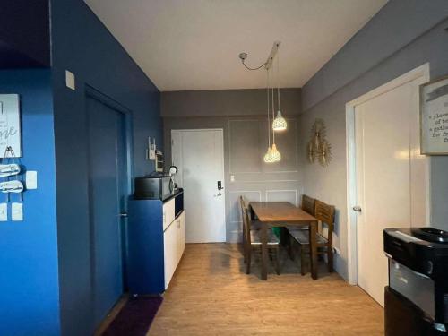 a kitchen with a table and a blue wall at Anuva Condo Staycation and Rent in Manila