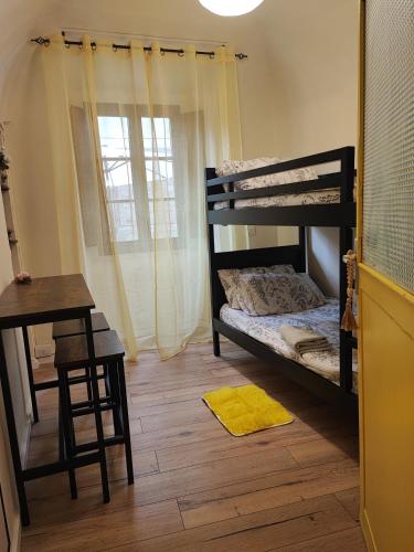 a bedroom with a bunk bed and a desk and a window at La casina nel borgo in Volterra