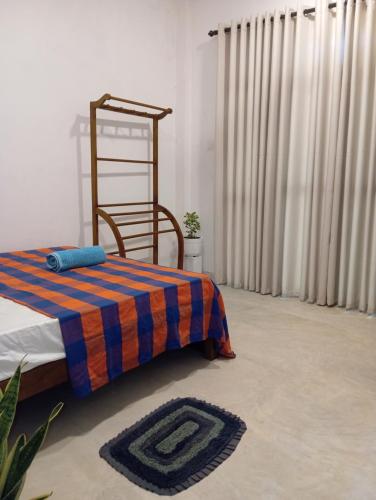 Un dormitorio con una cama, una manta y cortinas. en The Villa Hush - 02, en Hikkaduwa