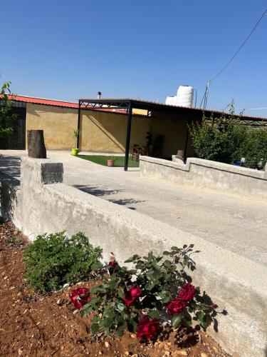a building with a bunch of flowers in a yard at شاليه جبال سوف in Jerash