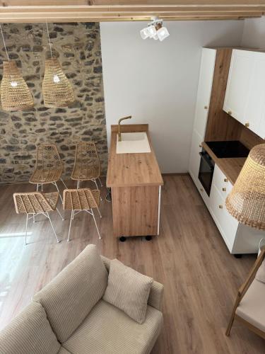 a living room with a couch and a table and chairs at Gîte plein de charme avec ses poutres apparentes , ses pierres et son jacuzzi extérieur in Caux