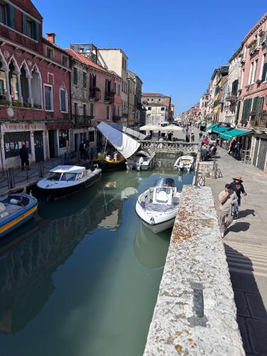 a group of boats docked in a canal with buildings at Ca' Elena beautiful canal view Biennale in Venice