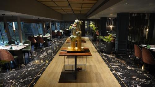 a long table in a restaurant with tables and chairs at Seasons Rajkot in Rajkot