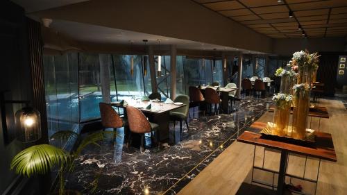 a restaurant with tables and chairs in a room at Seasons Rajkot in Rajkot