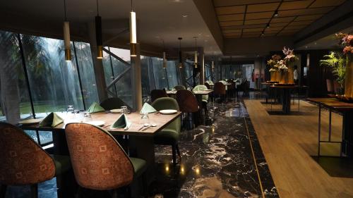 a dining room with tables and chairs and windows at Seasons Rajkot in Rajkot