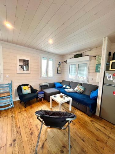 un salon avec un canapé bleu et une table dans l'établissement Le Chalet Beach Access 8 Pers, à Gruissan