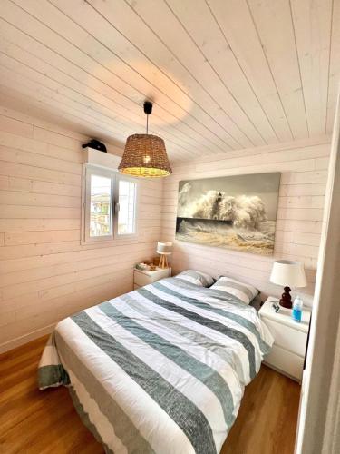 une chambre avec un lit et un tableau au mur dans l'établissement Le Chalet Beach Access 8 Pers, à Gruissan