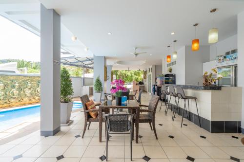a dining room with tables and chairs and a pool at Square One Hotel Patong in Patong Beach