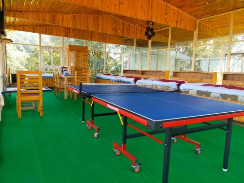a ping pong table in a room with beds at Smooky Villa in Mukteswar