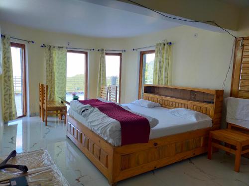 a bedroom with a large wooden bed and windows at Smooky Villa in Mukteswar