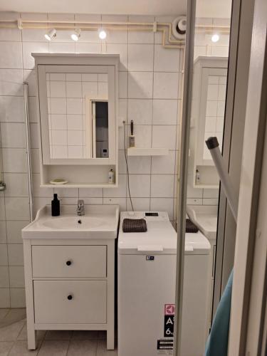 a small white bathroom with a sink and a mirror at Komfort in Lier