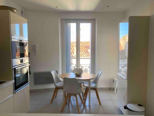 une salle à manger avec une table et des chaises dans une cuisine dans l'établissement appartement en plein centre ville, à Sète