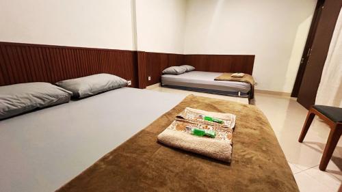 a room with two beds and a table in it at The Segaran House ONLY Syariah Unmarried Couple Not Allowed in Jakarta