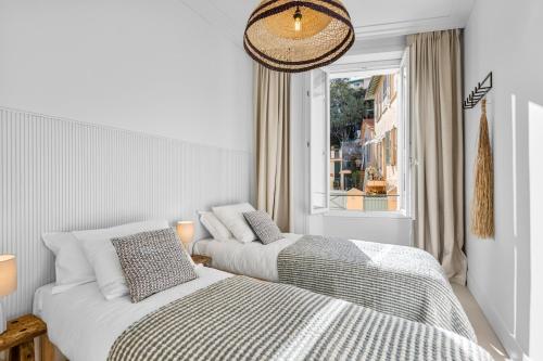 une chambre avec deux lits et une fenêtre dans l'établissement 2BR Boutique-Apartment in Cannes, strand- und zentrumsnah 10-15 Minuten, à Cannes