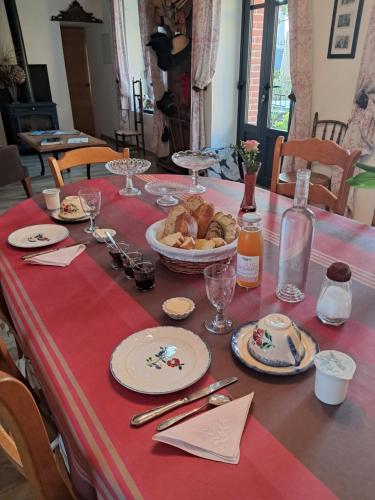 a table with a red table cloth with food on it at LE jardin in Coudeville