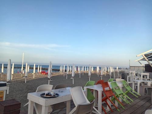 un grupo de sillas y mesas en la playa en Triremi house, en Lido di Ostia