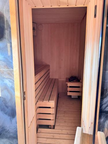 a sauna with a wooden bench in a room at Mountain paradise Премиум дача в Чимгане in Chimgan